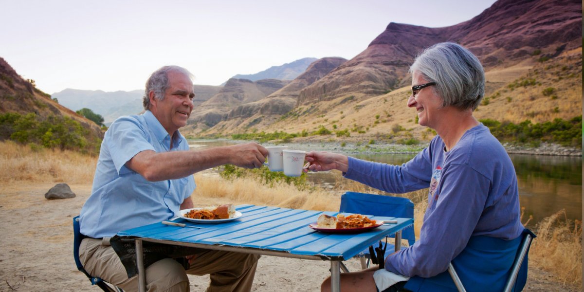 A couple enjoys a delicious dutch oven meal on their ROW Adventures rafting trip