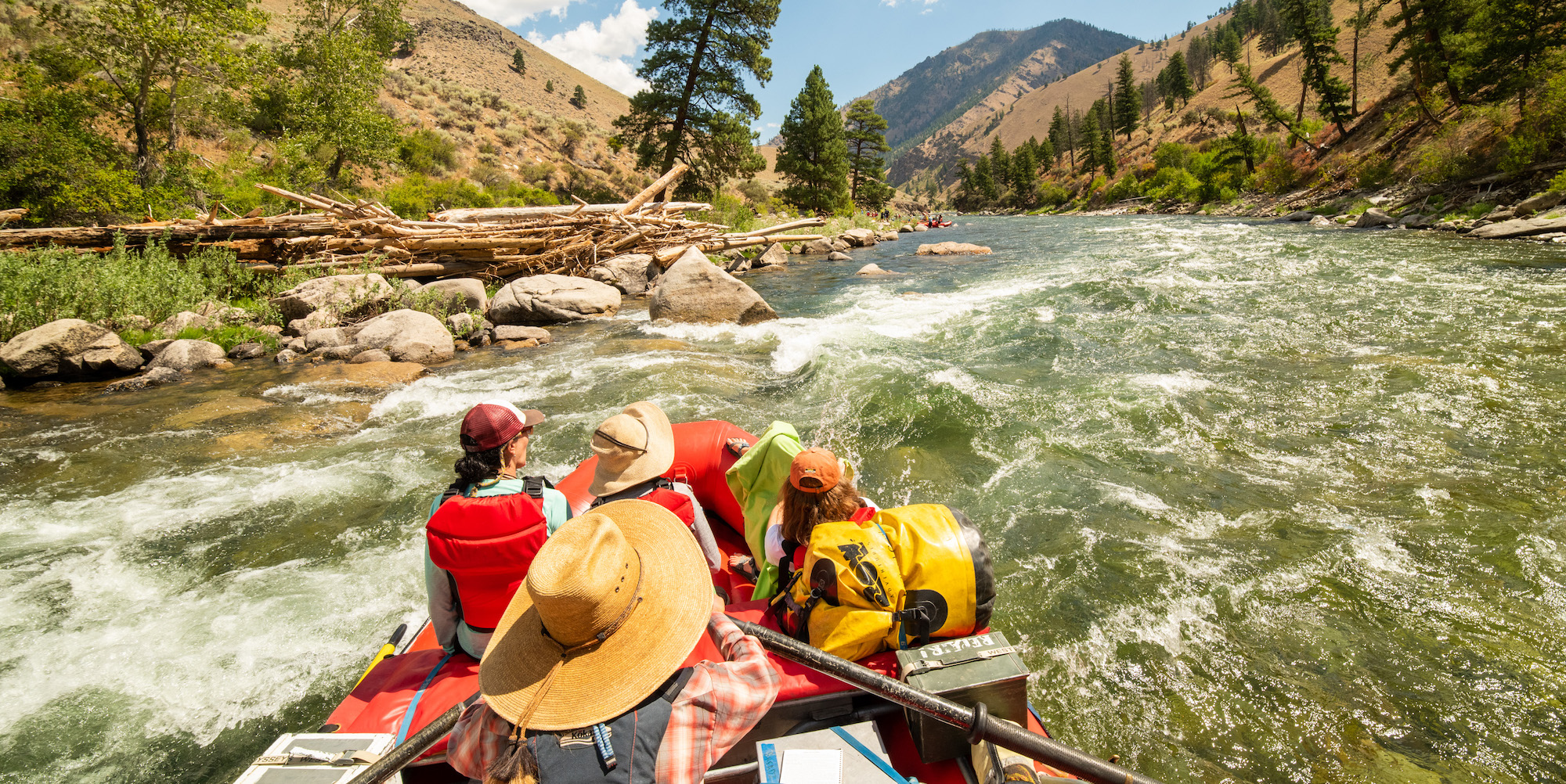 Top down shot of a river guide rowing two guests on their boat down the Middle Fork Salmon River on a sunny day