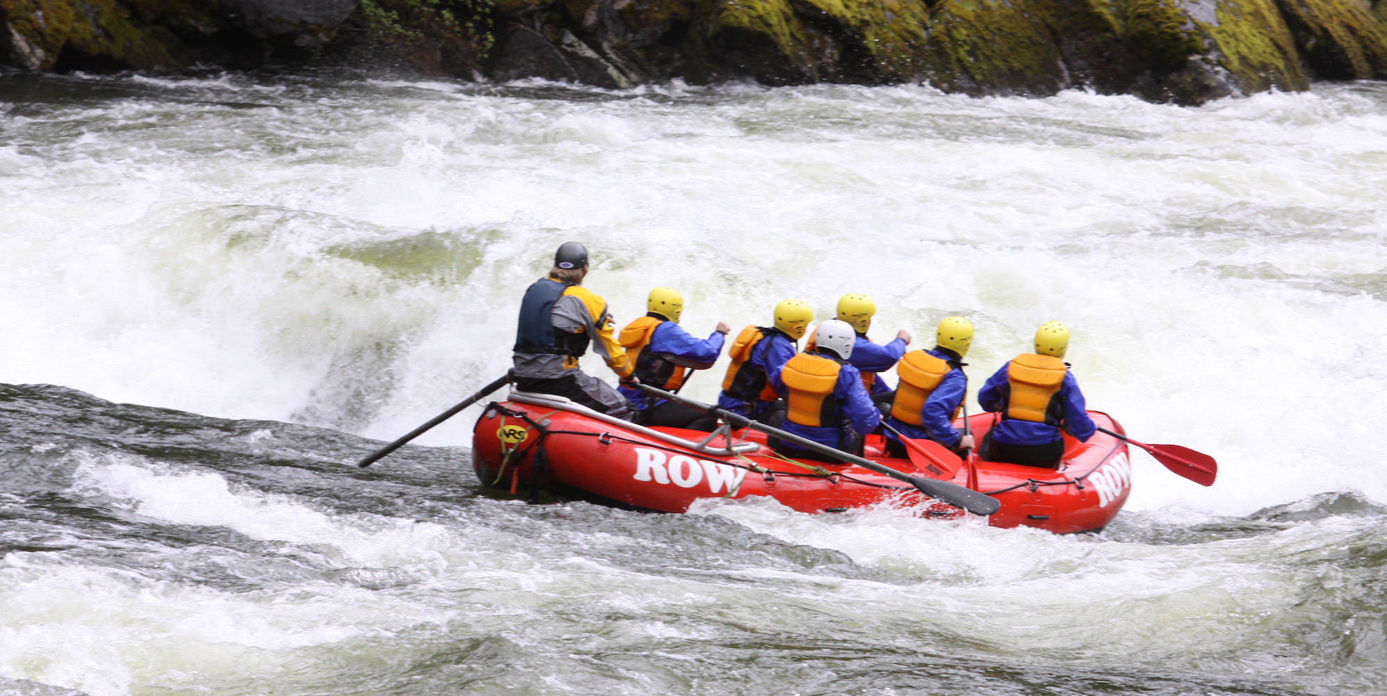 Red raft full of passengers from behind about to enter a big whitewater rapid on the Lochsa River