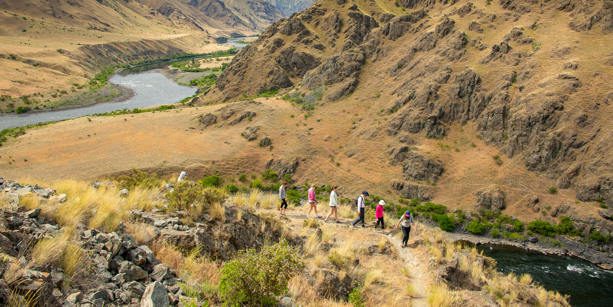 A group of people hiking along the Idaho side of the Snake River through Hells Canyon