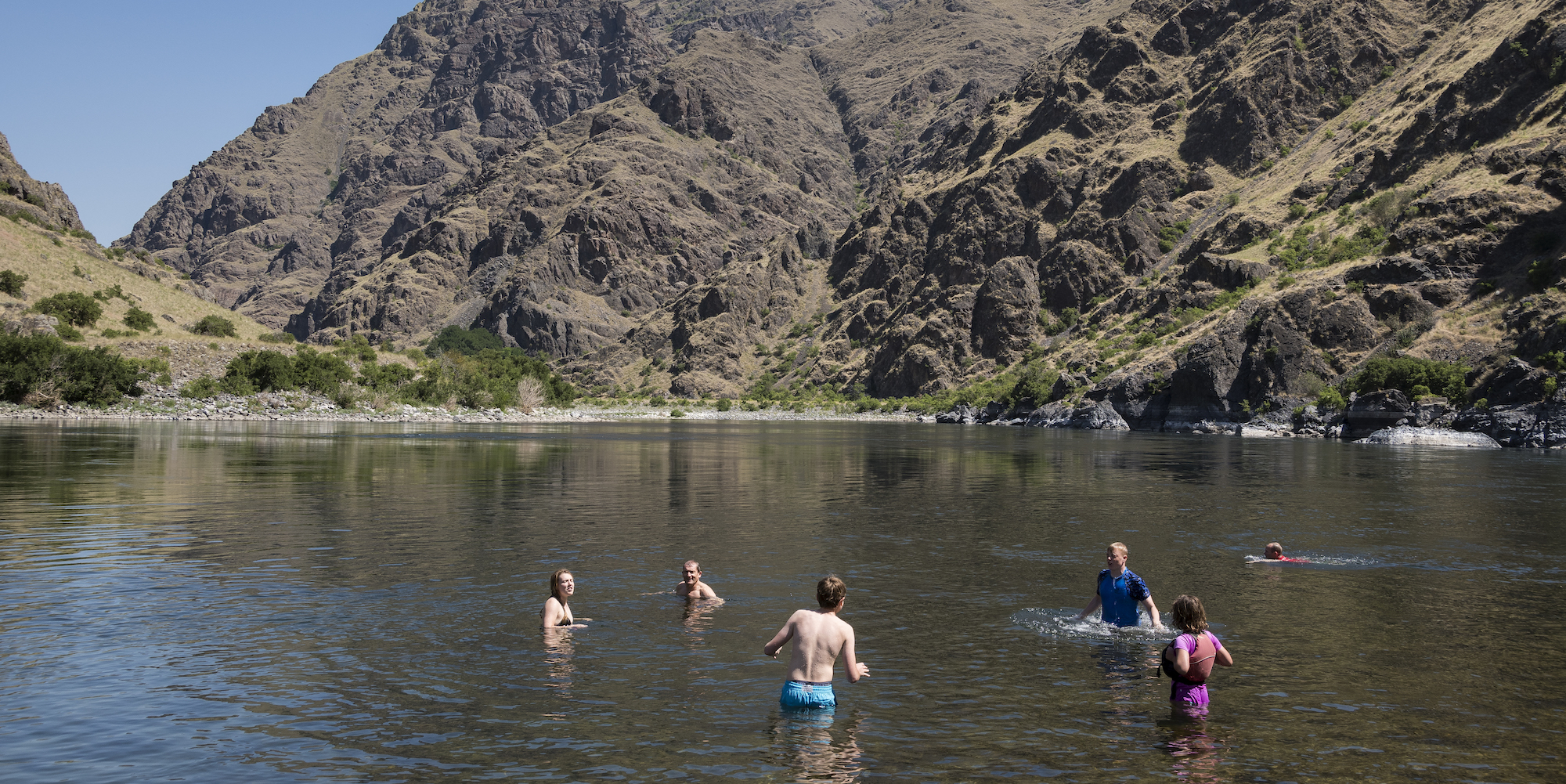 A group of people swimming and bathing in the Snake River