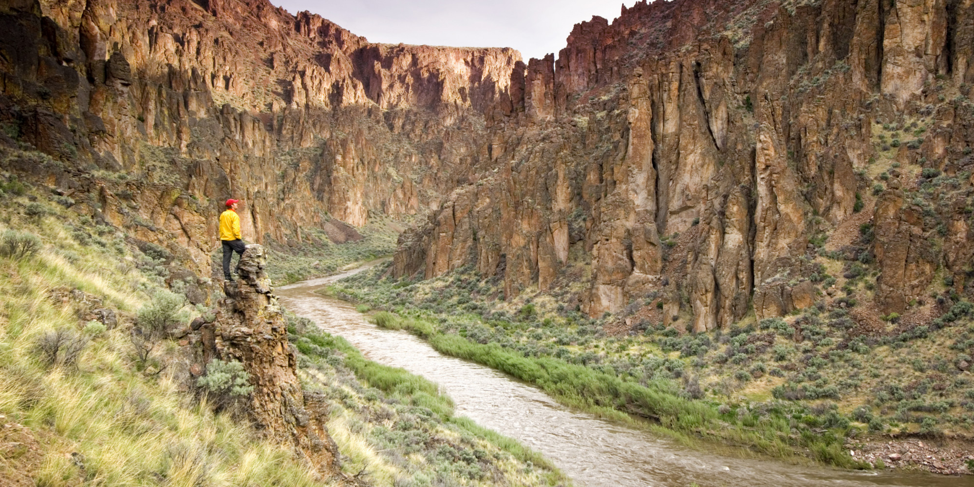 Person standing on a rock above the Owhyee River admiring the Grand Canyon of Oregon