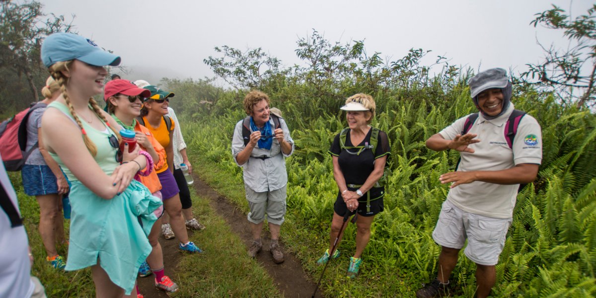 ROW Guests laughing with a Galapagos Guide on a hike through a National Park in the Galapagos Islands
