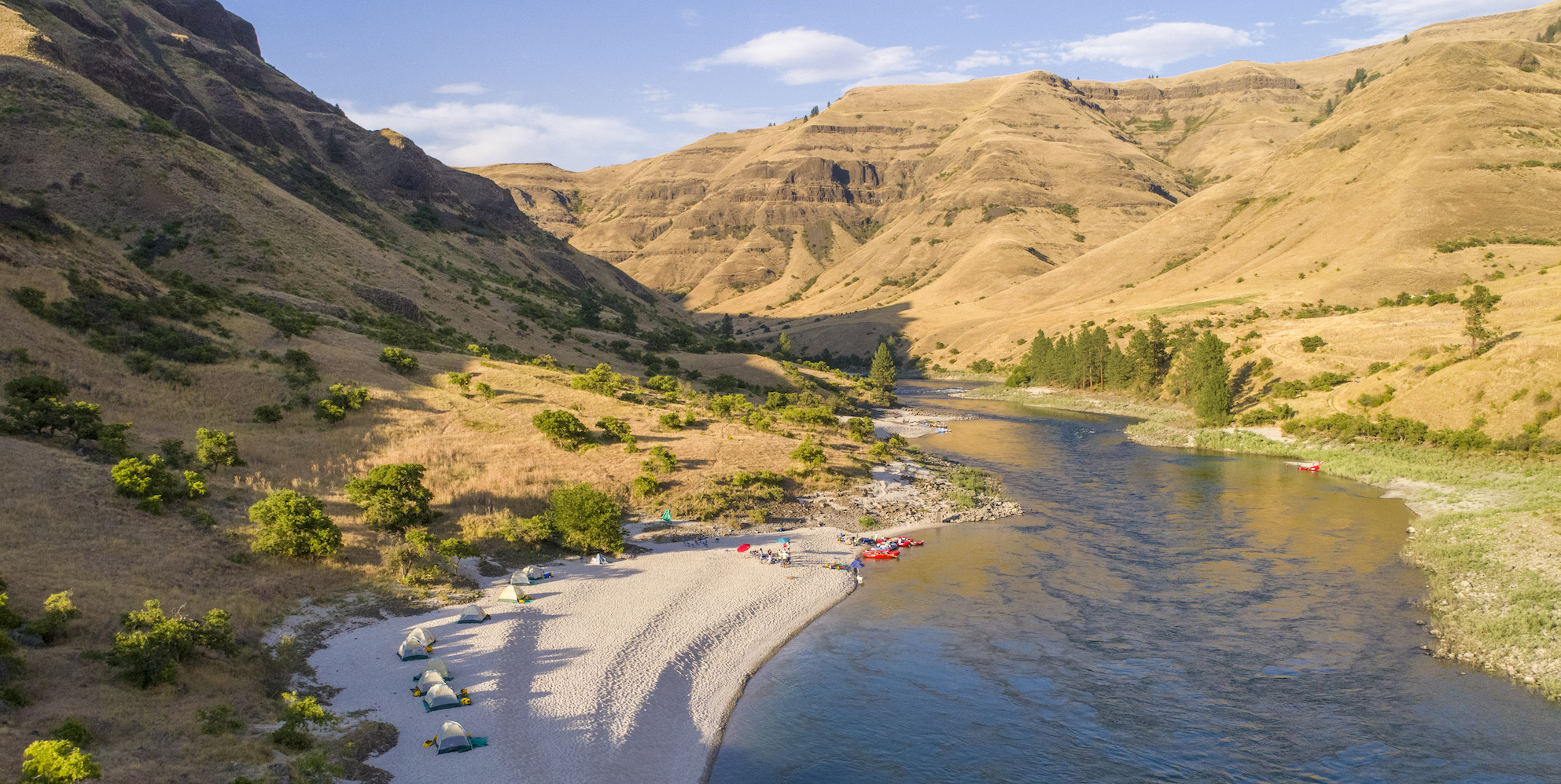 Ariel view of a group of whitewater rafters camping along a sandy beach on the Lower Salmon River in Idaho