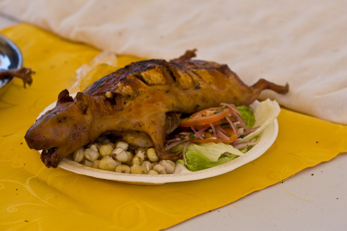 Traditional Ecuadorian whole roasted pig over vegetables on a white plate