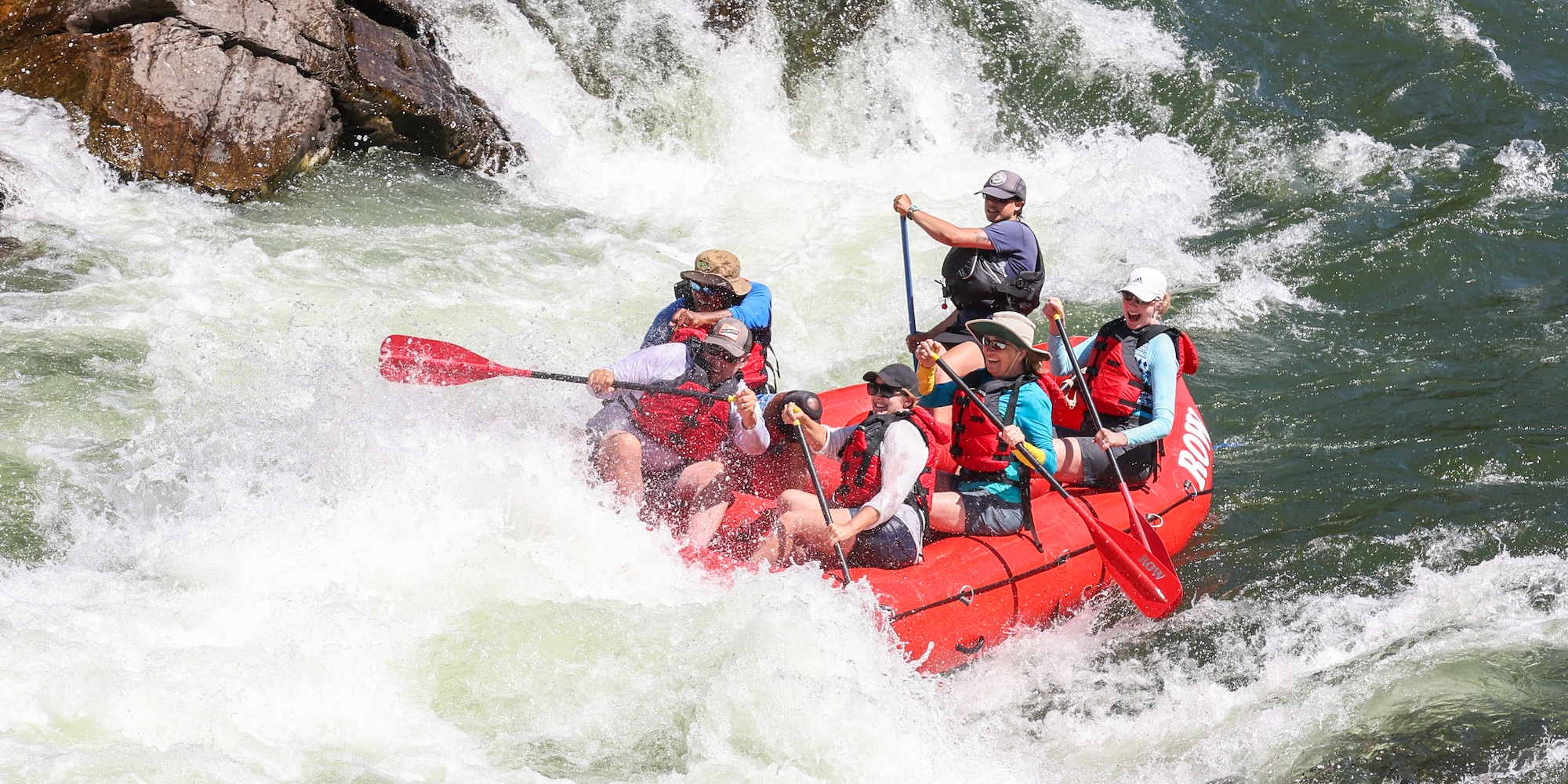 Group whitewater rafting through splashy rapids on the Clark Fork River in Montana, an exciting one-day rafting trip perfect for a short outdoor vacation.