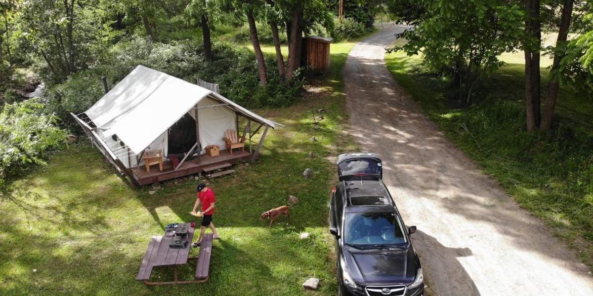 A happy "glamper" unpacks his vehicle and prepares for a relaxing stay in a glamping tent at River Dance Lodge. 