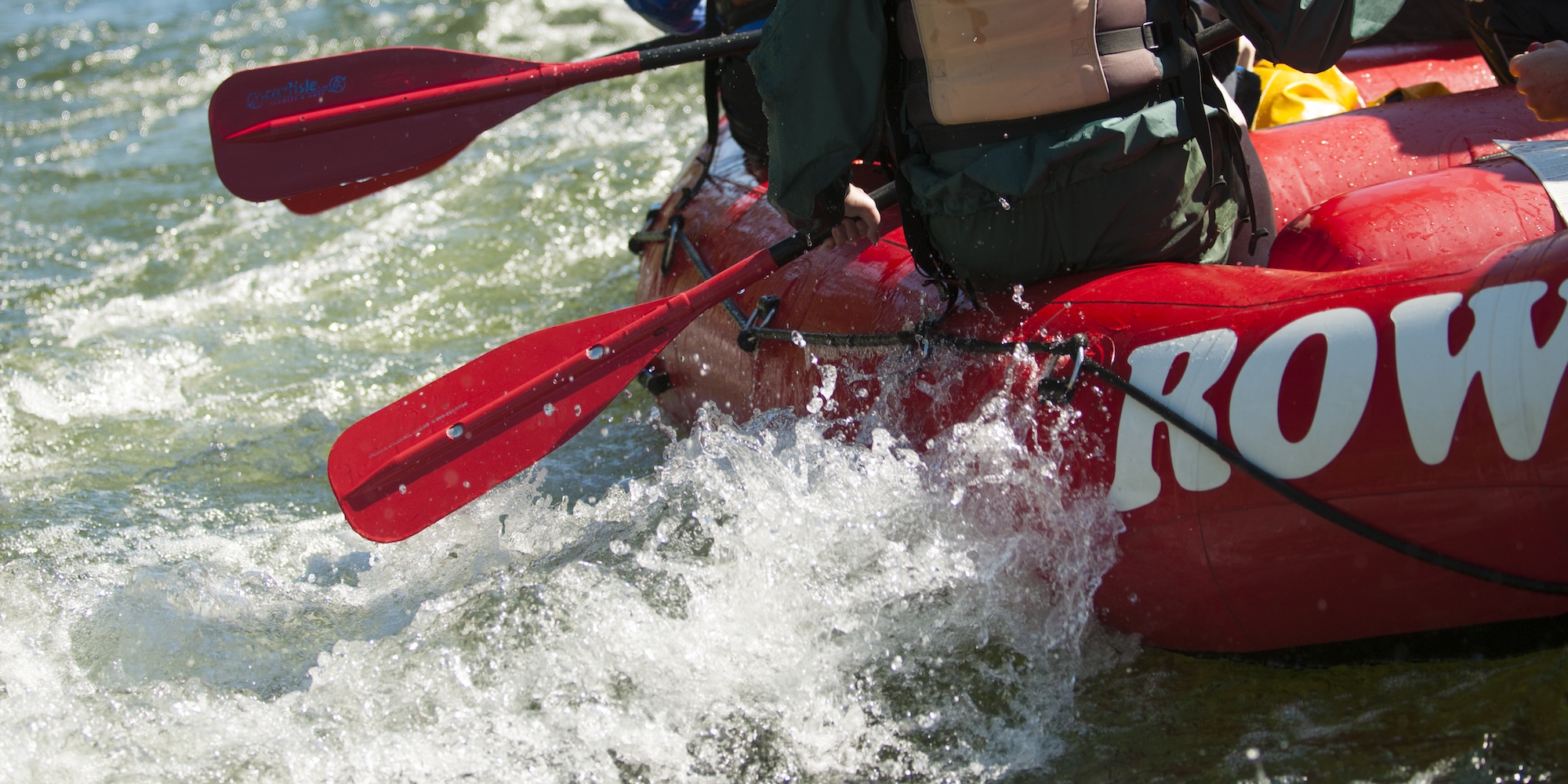 Rafters paddling through splashy whitewater on the Middle Fork of the Salmon River, fully engaged in the movement and rhythm of the river.