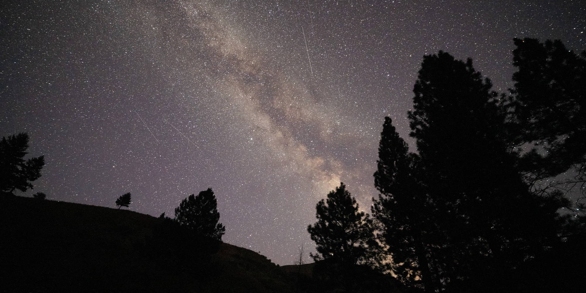 The Milky Way glowing above a forested river canyon, showing why this is one of the best places to see the Milky Way.