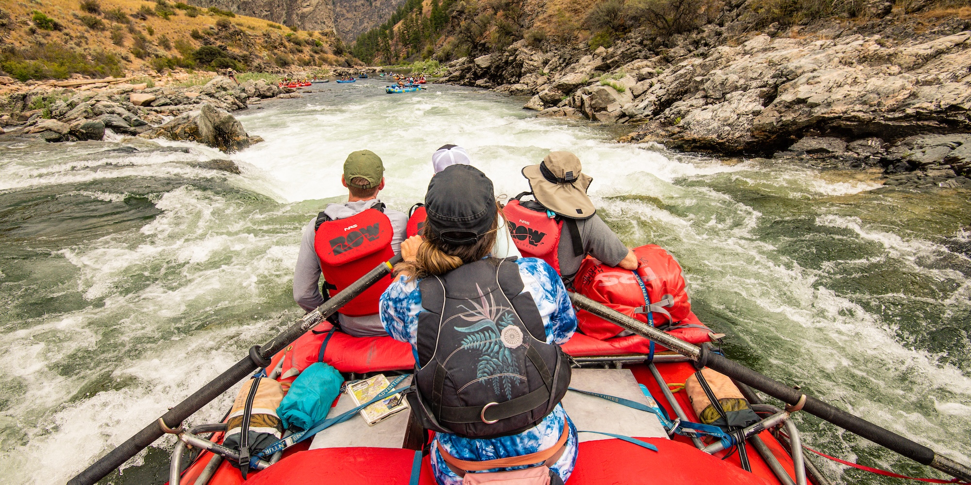 View from the back of an oar boat as it approaches Tappan Falls on the Middle Fork of the Salmon River, surrounded by rocky canyon walls.