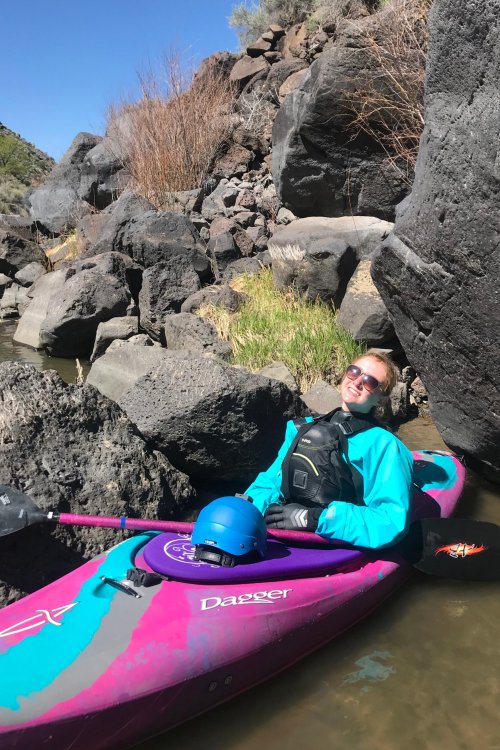 female in pink and blue whitewater kayak