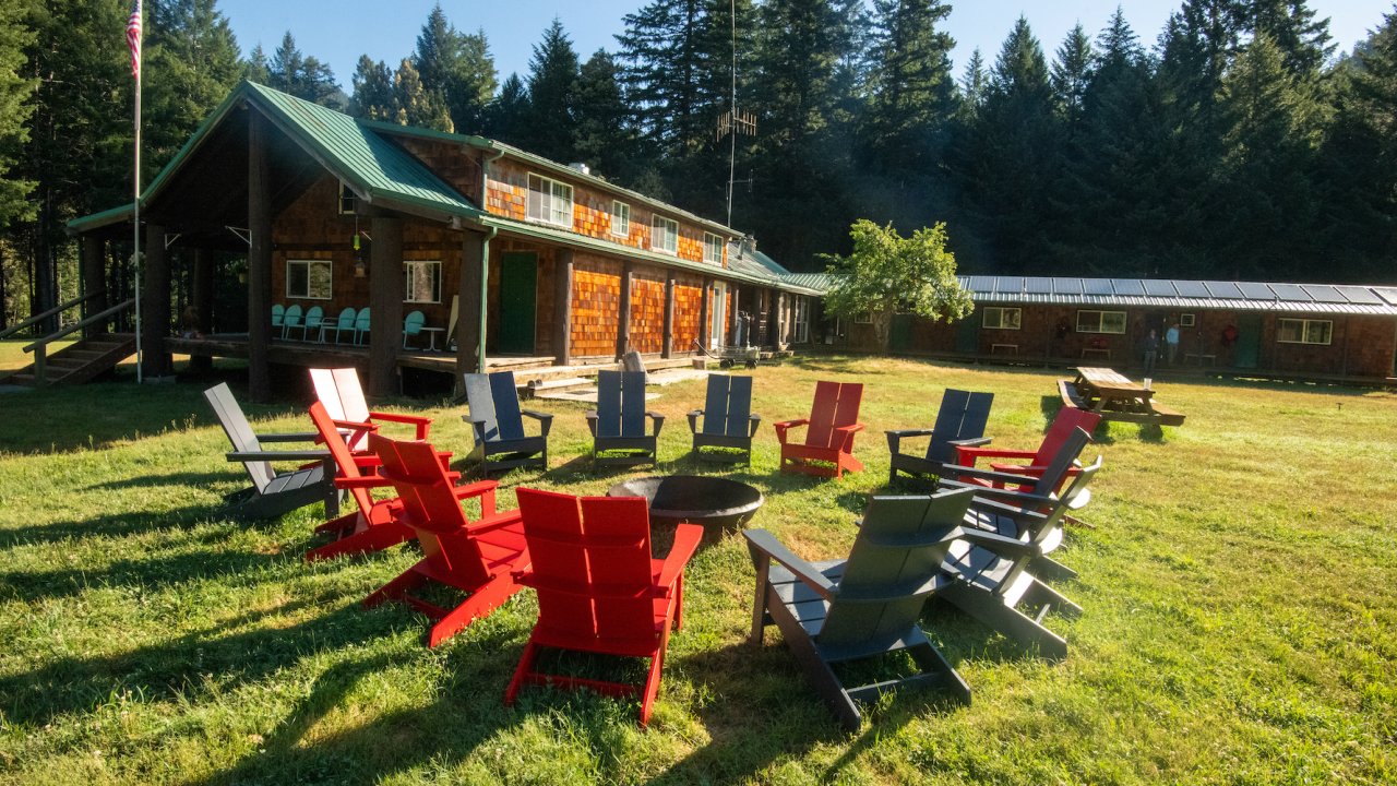 Circle of Adirondack chairs outside Half Moon Bar Lodge along the Rogue River