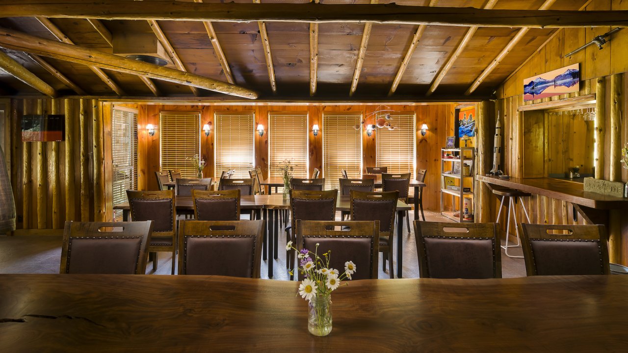 Empty tables and kitchen window in a lodge mess hall room