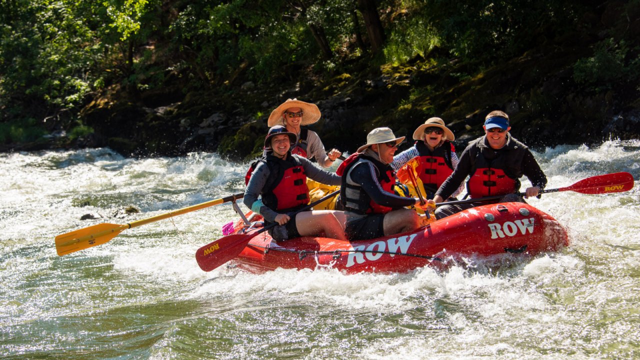 red raft with 5 people on the rogue river in Oregon