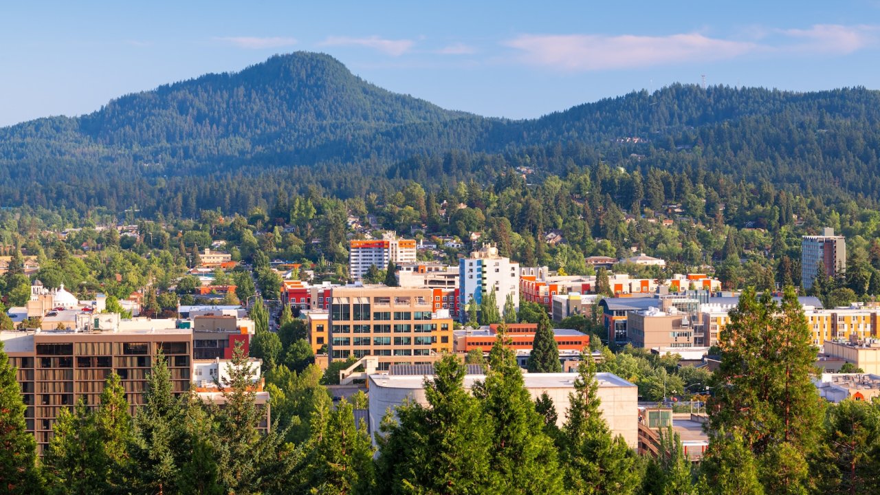 Downtown Eugene, Oregon with surrounding forested hills, showcasing the city’s blend of urban energy and outdoor adventure.