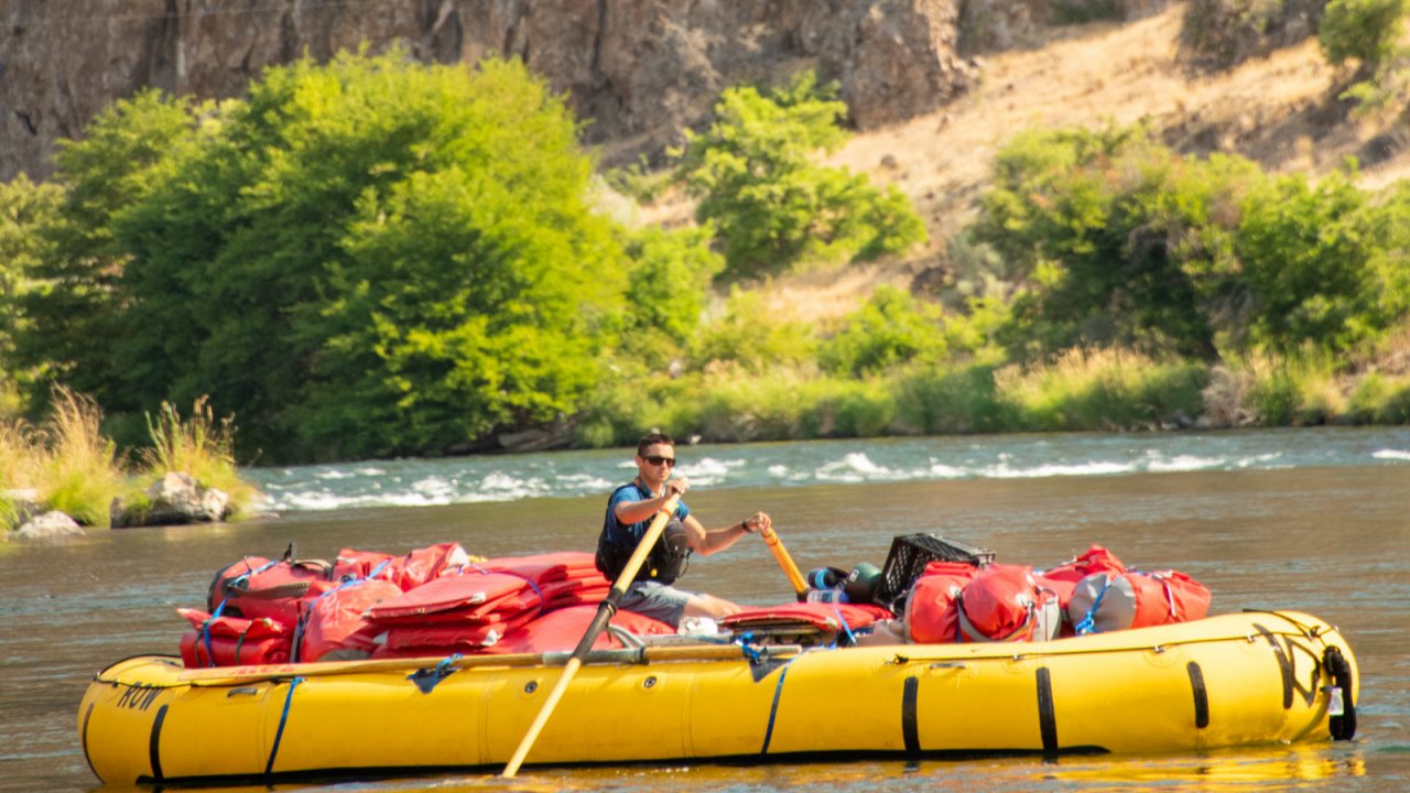 Alex enjoying some peace and quite on the Deschutes River cargo boat. yellow cargo raft with guide