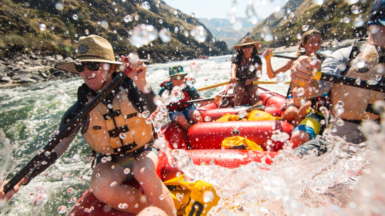A family rowing through a rapid with a guide in Idaho