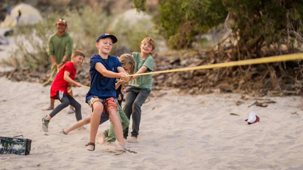 A group of kids playing tug of war on a sandy beach in Idaho