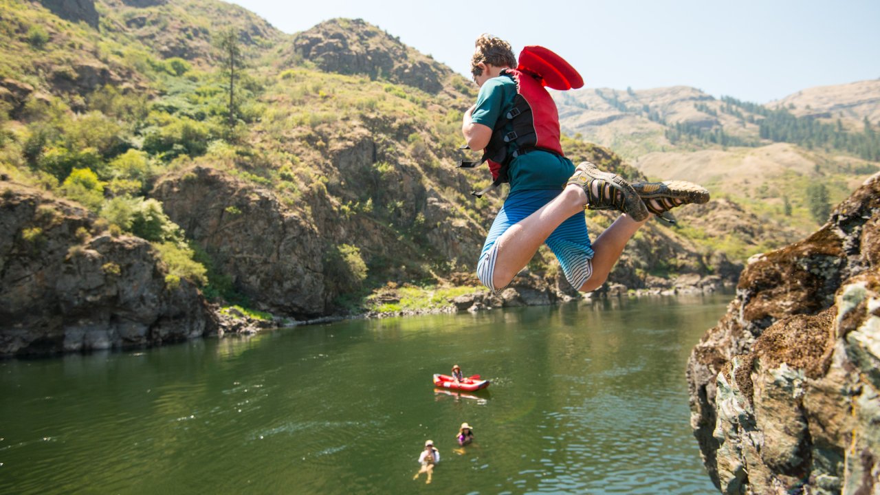 A kid cliff jumping on a guided rafting tour in Idaho