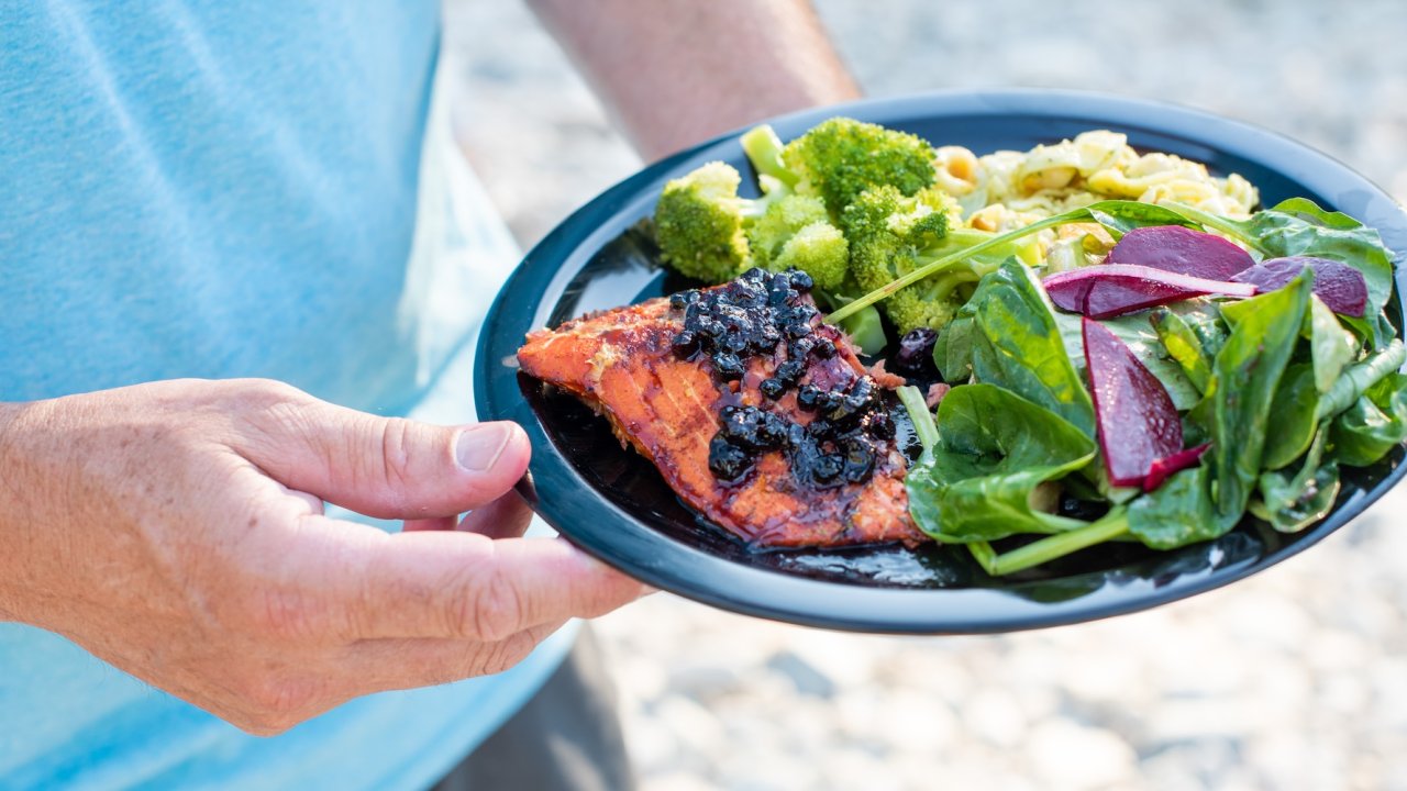 Backcountry dining on Idaho hiking tour with fresh salmon and vegetables