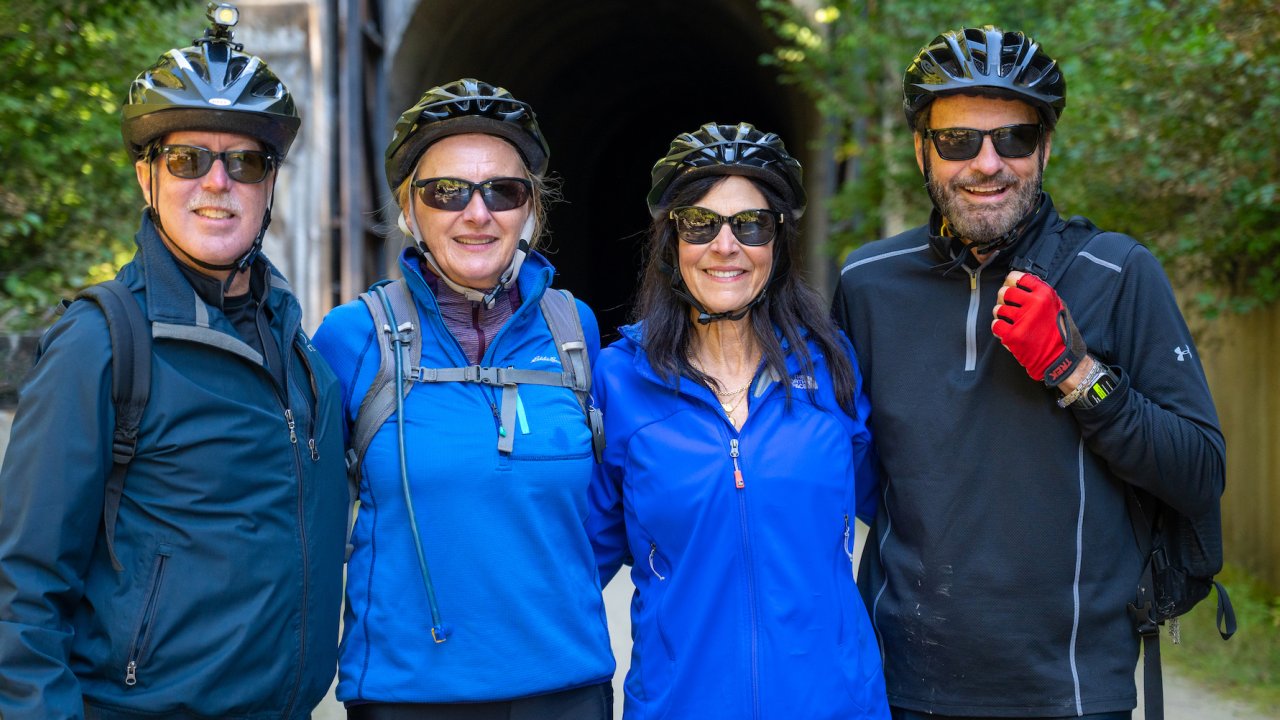 Cyclists posing at a tunnel entrance on the Banks-Vernonia Trail during a guided Oregon cycling tour