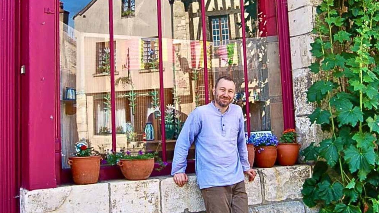 man in front of french shop