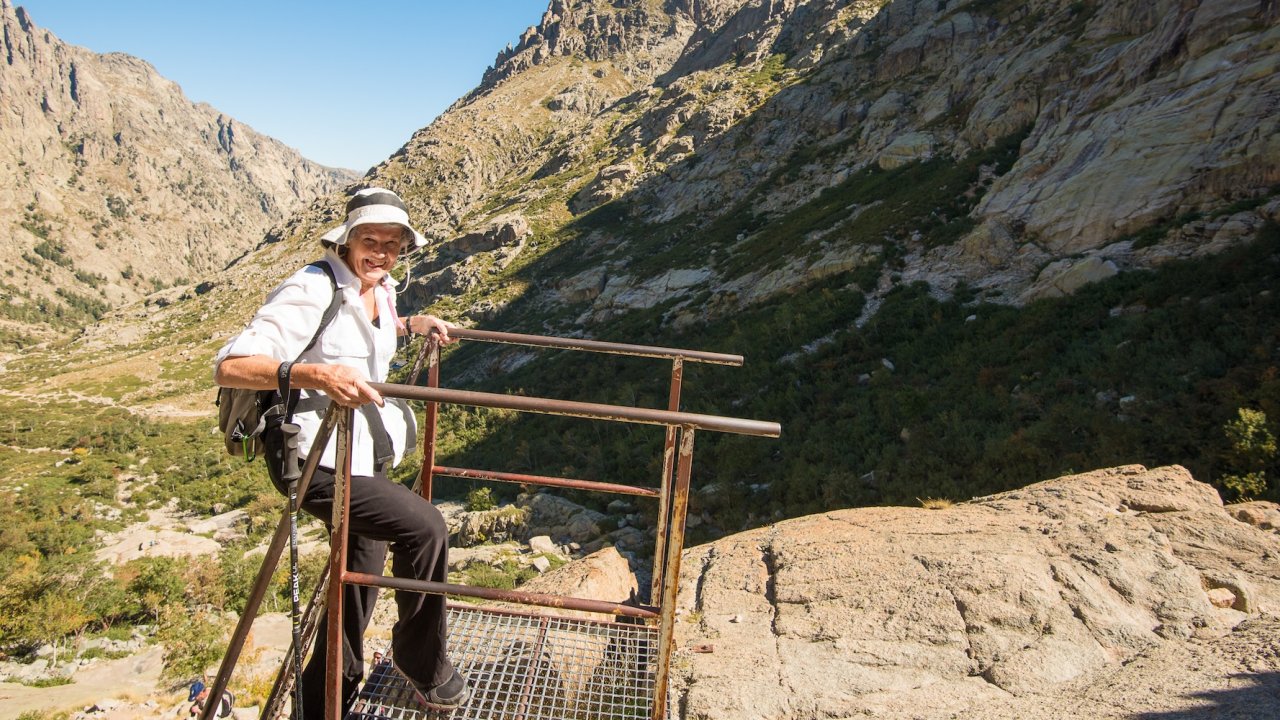 A traveler pauses at a mountain viewpoint during a guided Corsica tour, taking in the rugged alpine landscapes of the island’s interior.