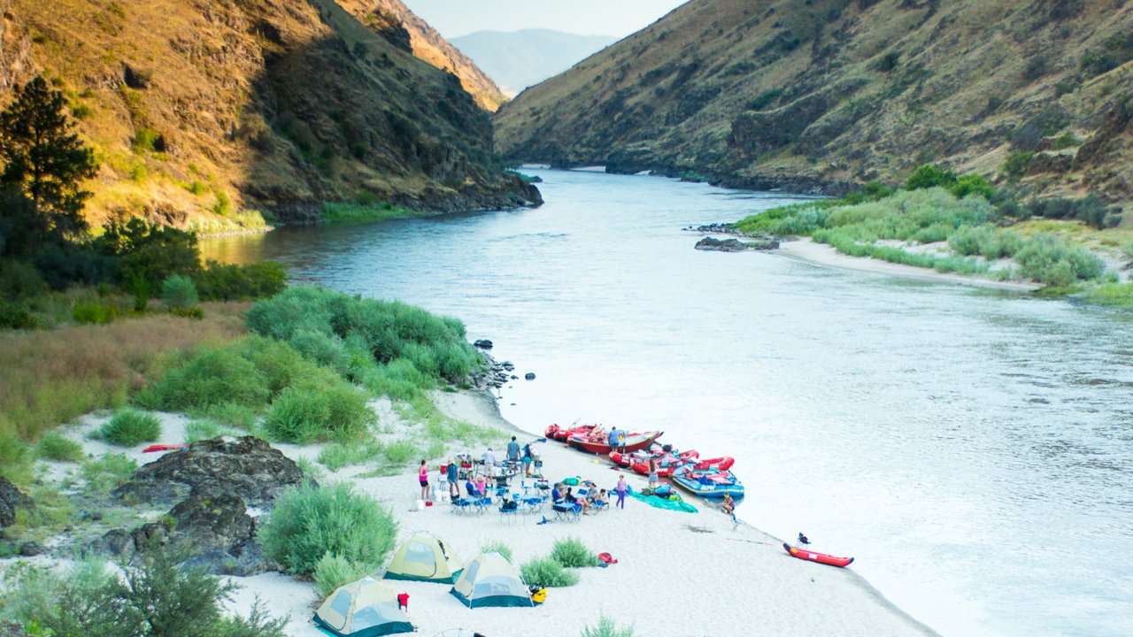 rafting camp set up on sandy beach along river