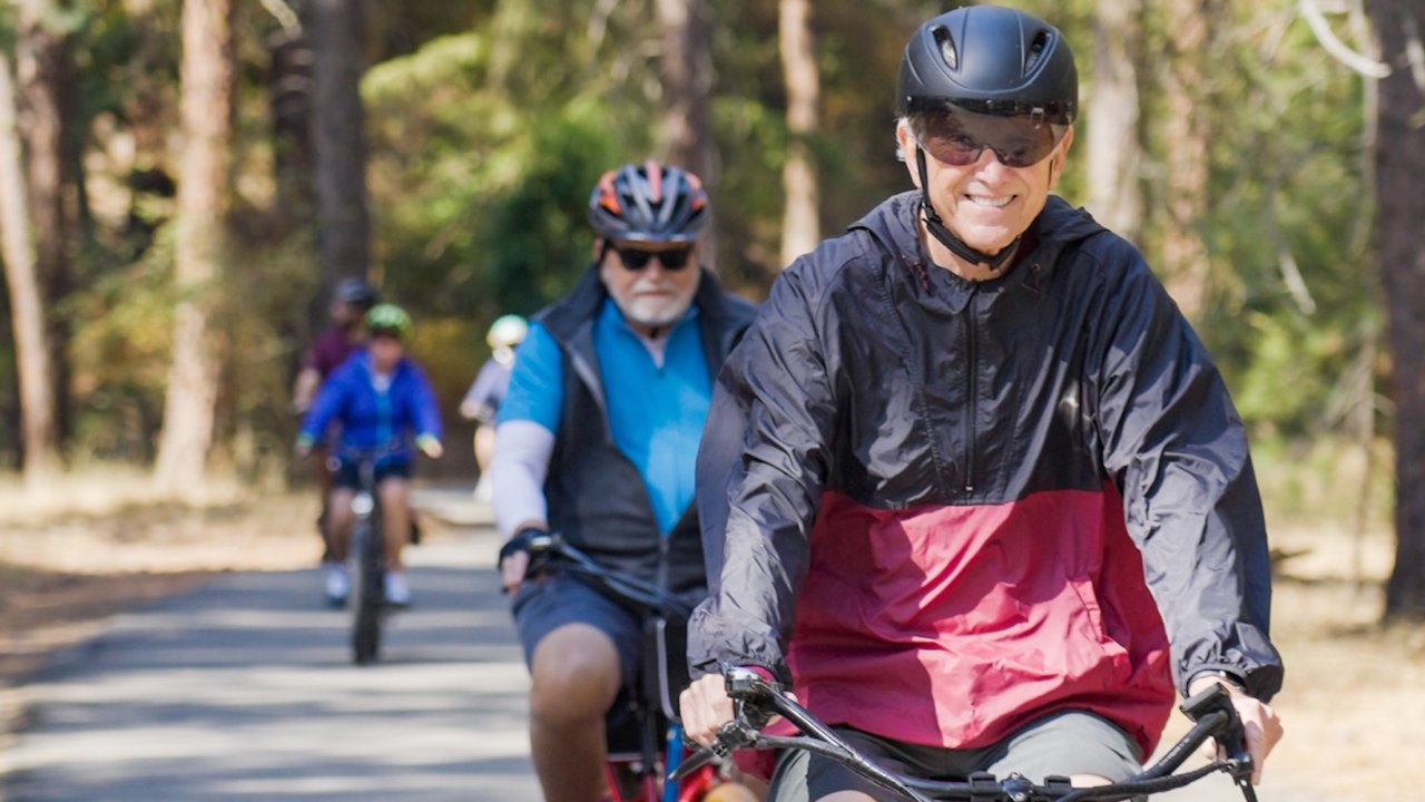 Guests cycling together on a shaded forest trail during a guided Oregon bike tour