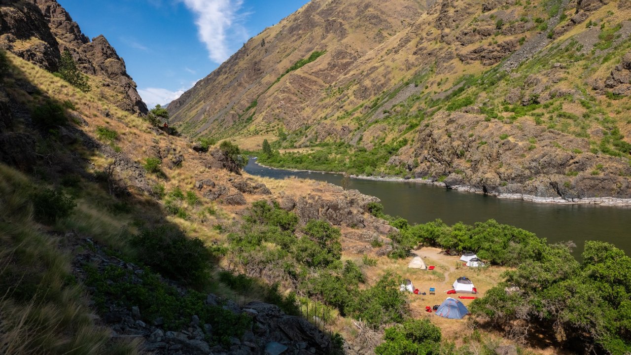 Snake River campsite tucked between steep canyon walls along the Snake River Canyon Trail, a multi-day Hells Canyon hiking adventure.