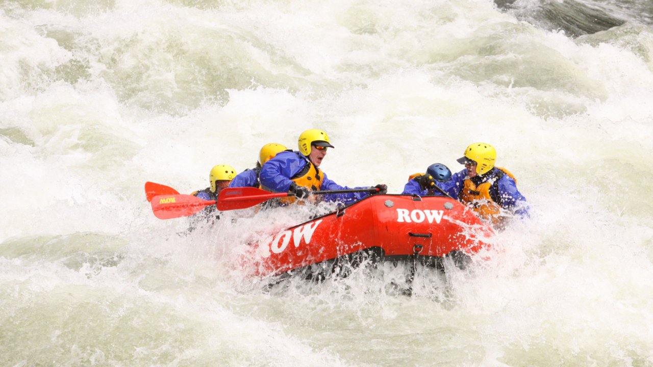huge whitewater with a red raft in the middle