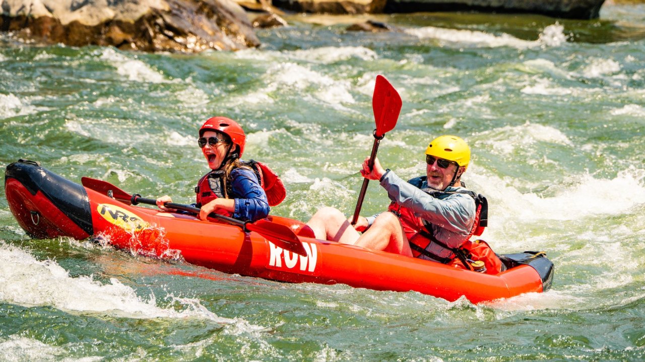 Guests enjoying a tandem inflatable kayak while rafting the Salmon River in Idaho.