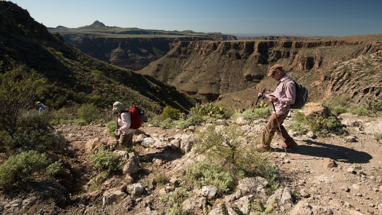 Guided hiking tour near Loreto, Mexico, with travelers trekking rugged canyon trails on the way to see the Santa Teresa cave paintings.