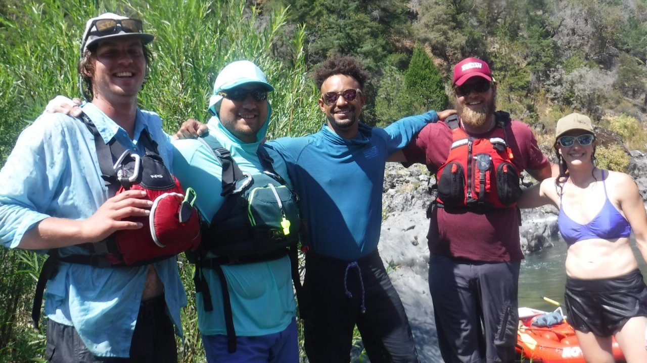 Our Rogue River crew enjoys a short riverside break! team of river guides standing arm in arm