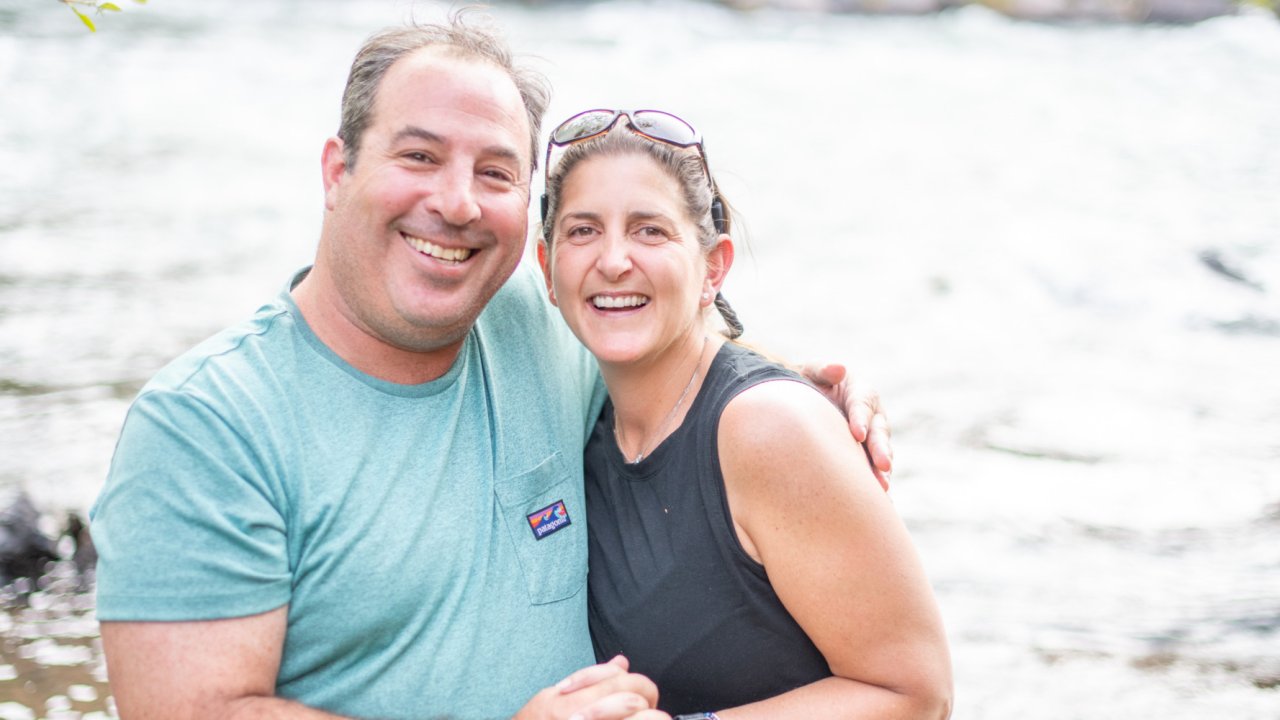 Happy couple smiling at camp on a multi-day whitewater rafting trip