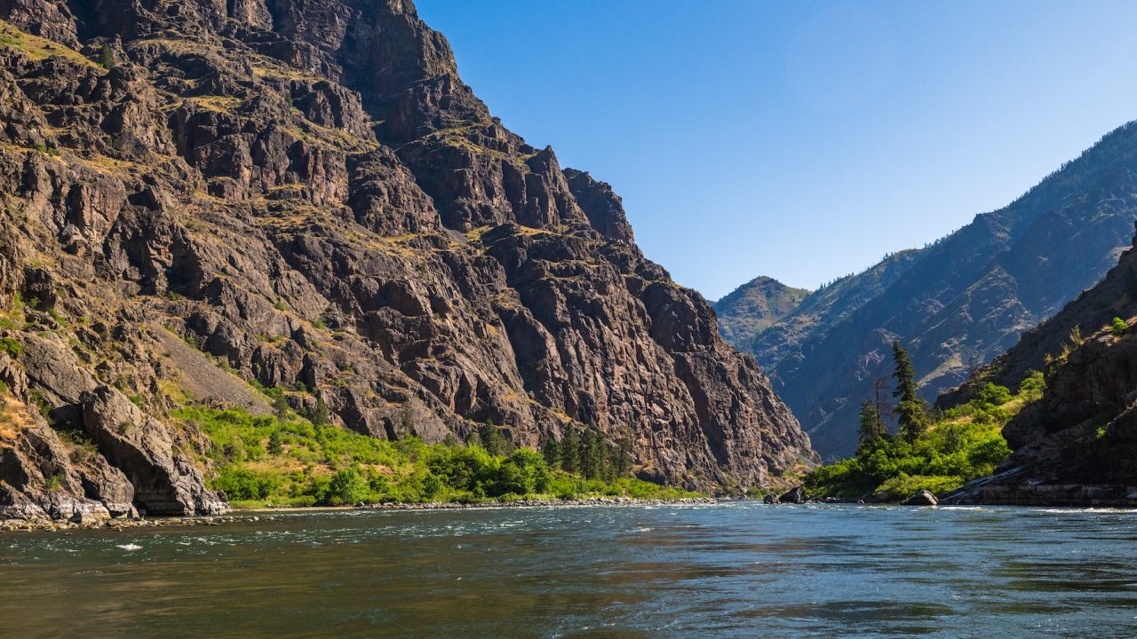 Scenic view of the Salmon River winding through Idaho’s dramatic canyons, an inspiring destination for whitewater rafting and wellness travel retreats.