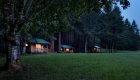A row of cabins in a green field surrounded by trees in the Rogue River Wilderness in Oregon