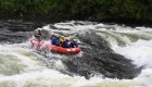 A red raft full of paddlers entering the tongue of a rapid on the Lochsa River