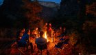 People sitting around a campfire while camping along the Bruneau River