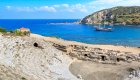 A sail boat with rooms aboard cruising past a historic amphitheater in Turkey