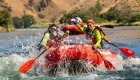 Rafting guests paddling a red whitewater raft on the Deschutes River