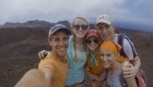 a family of four smiling for a photo atop a volcano hike