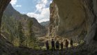 A group of people from the back looking up at a rock structure on a hike along the Salmon River in Idaho