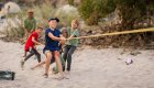 A group of kids playing tug of war on a sandy beach in Idaho