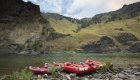 Red rafts tied up to shore along the Salmon River on a cloudy day