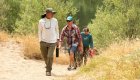 Hikers walking from the Rogue River into the Rogue River Wilderness
