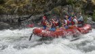 Group of paddlers in a red white water raft working through a rapid on the Snake River 
