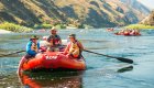 Parents relaxing on a red raft while floating flat water on the Lower Salmon River