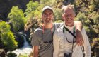 To people smiling for a photo while hiking along the Rogue River