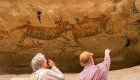 Two tourists pointing and taking pictures of the ancient cave paintings in Santa Teresa Canyon, Baja California